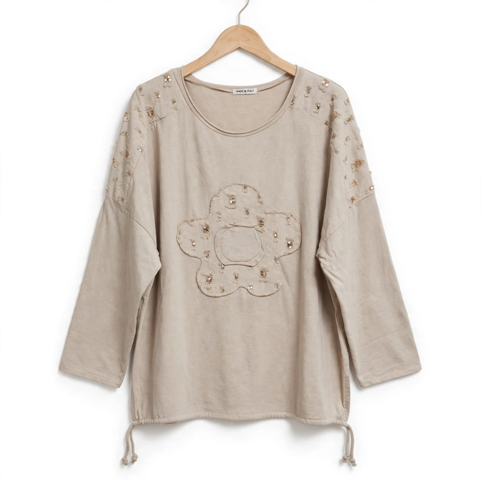 Blusa de algodón color arena de las cucadas de erisa con aplique floral, lentejuelas y detalles brillantes en hombros.