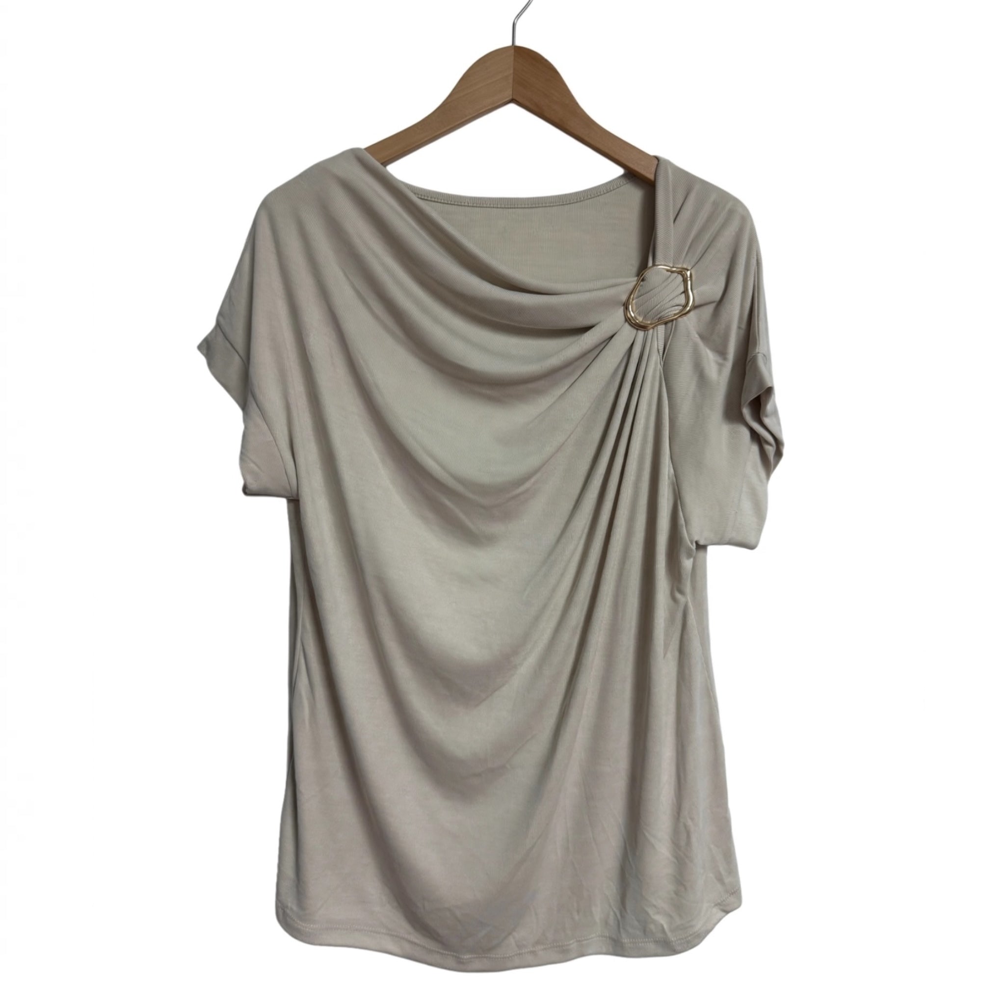 Blusa beige las cucadas de erisa con drapeado frontal, escote asimétrico y detalle de anilla metálica dorada.