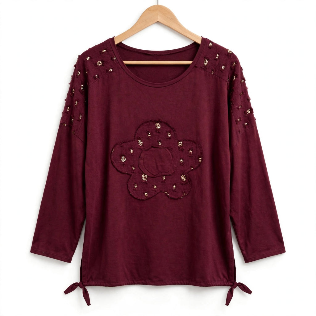 Blusa burdeos las cucadas de erisa con lentejuelas doradas, detalle de flor central y lazos ajustables en el bajo.
