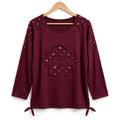 Blusa burdeos las cucadas de erisa con lentejuelas doradas, detalle de flor central y lazos ajustables en el bajo.