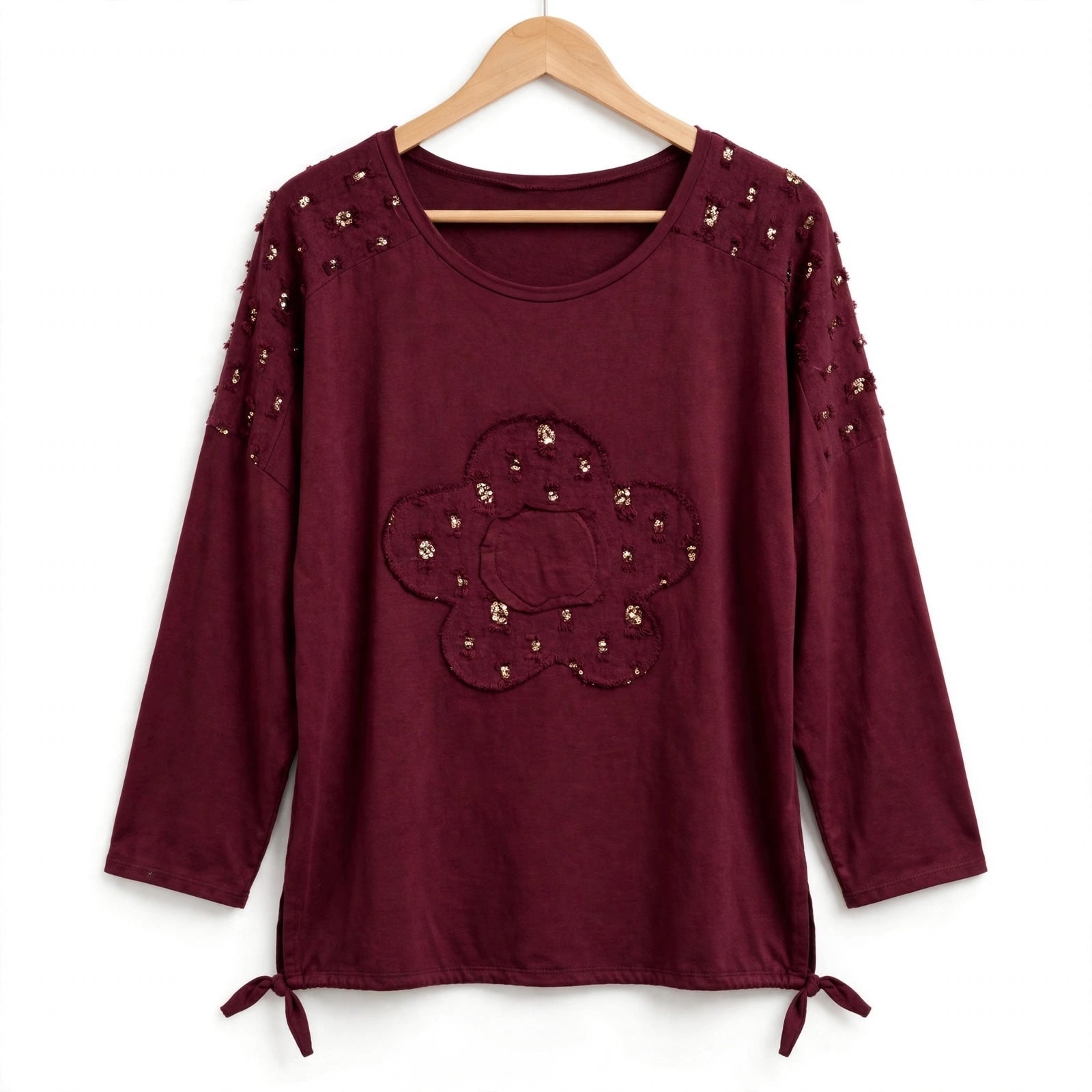 Blusa burdeos las cucadas de erisa con lentejuelas doradas, detalle de flor central y lazos ajustables en el bajo.