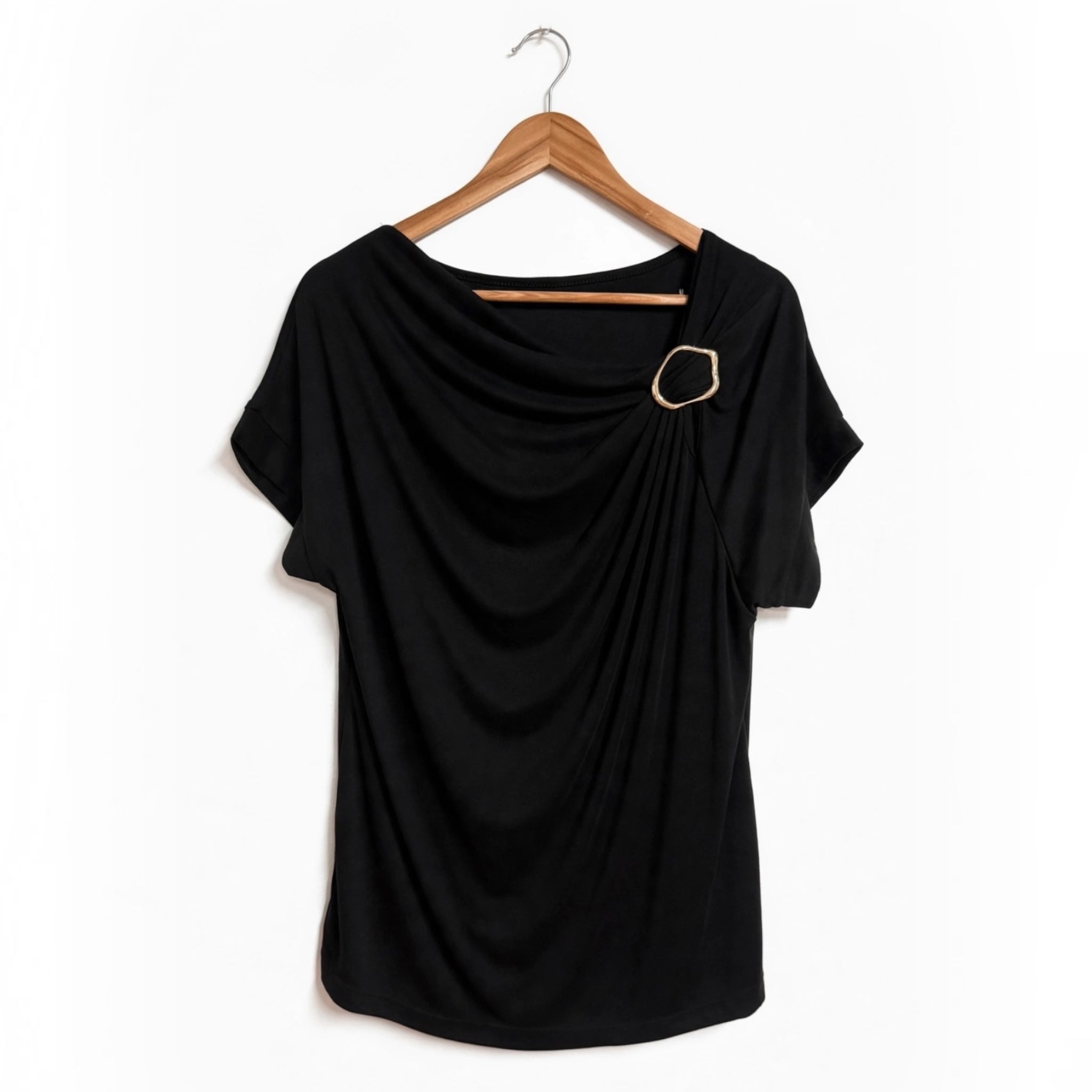 Blusa negra las cucadas de erisa con drapeado frontal, escote asimétrico y detalle de anilla metálica dorada.