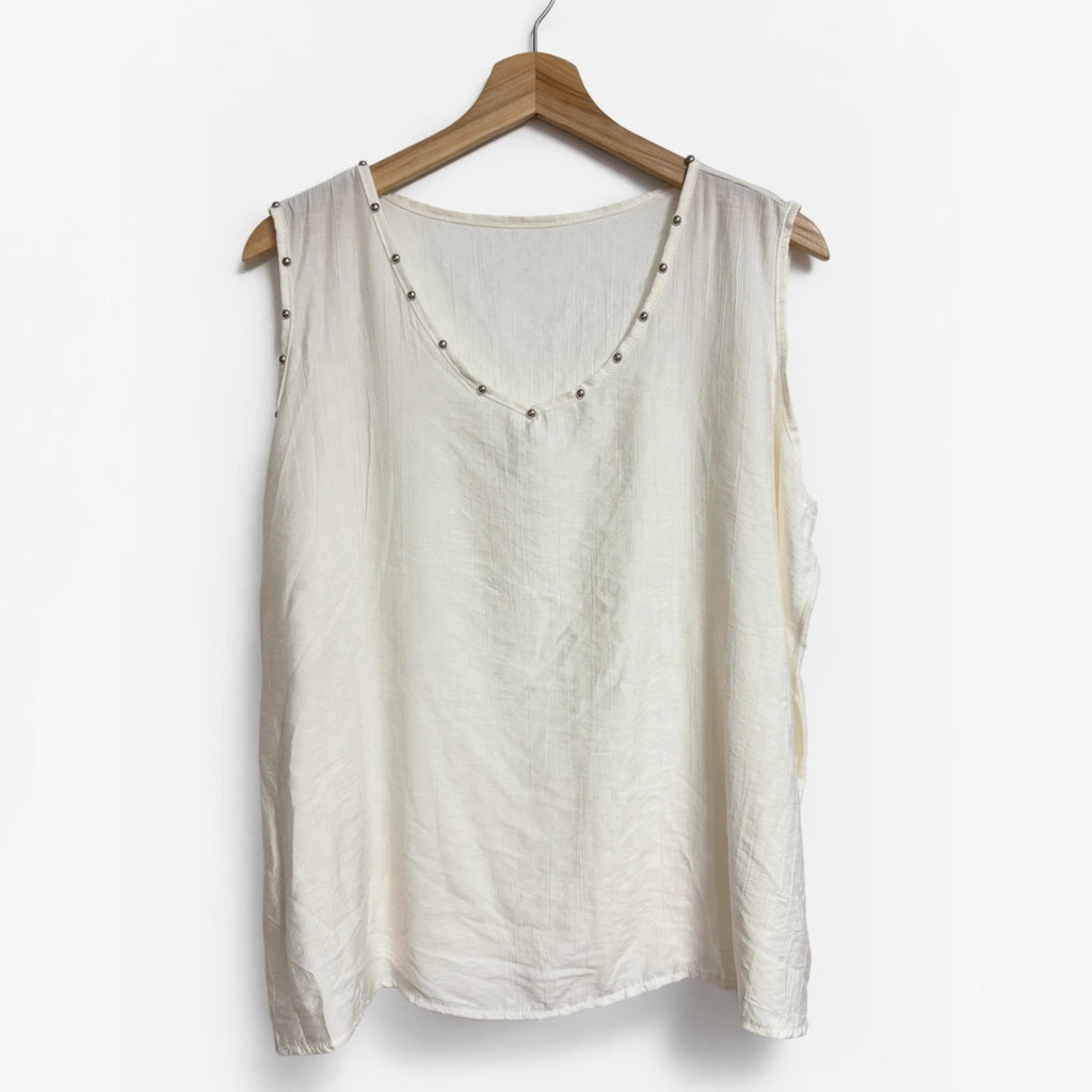 Blusa sin mangas color crema de las cucadas de erisa con detalle de tachuelas metálicas en el escote y sisas