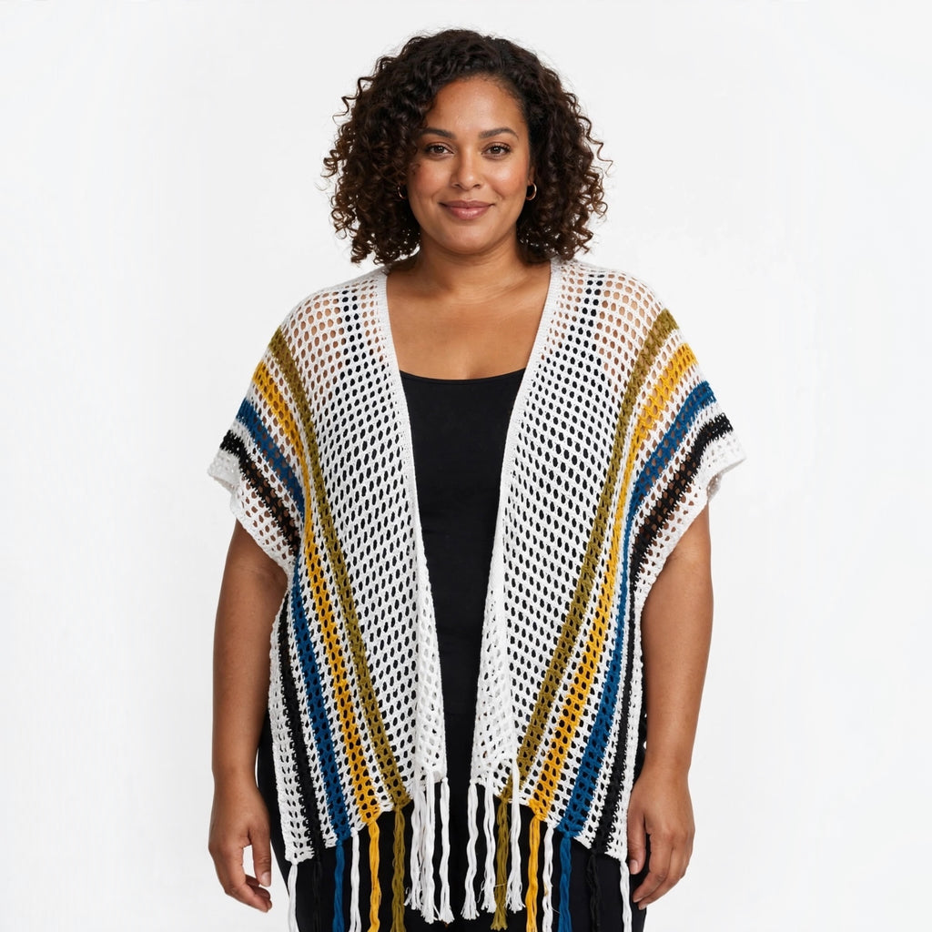 Modelo vistiendo cárdigan las cucadas de erisa de crochet blanco con rayas mostaza, azul y negro y flecos en el bajo