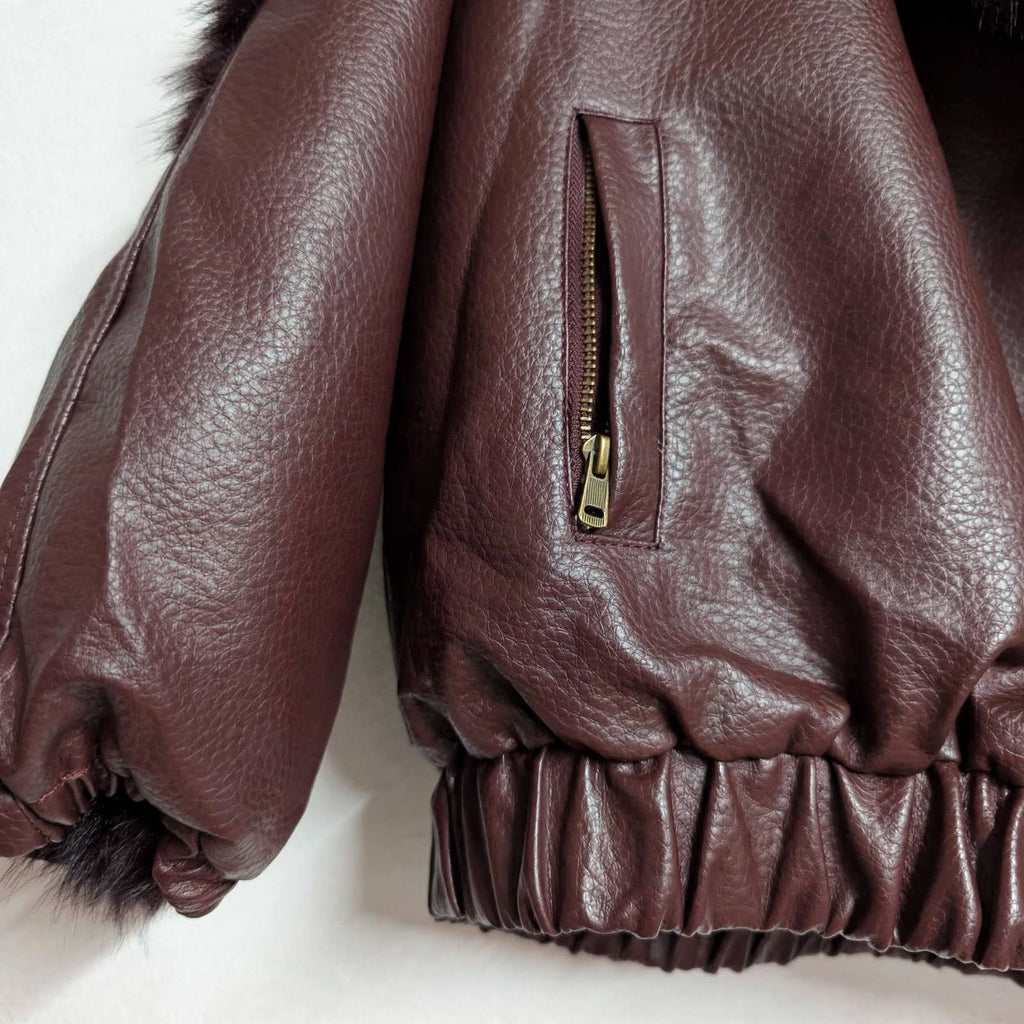 Detalle de chaqueta reversible las cucadas de erisa en piel sintética burdeos con cremallera bronce y bajo elástico