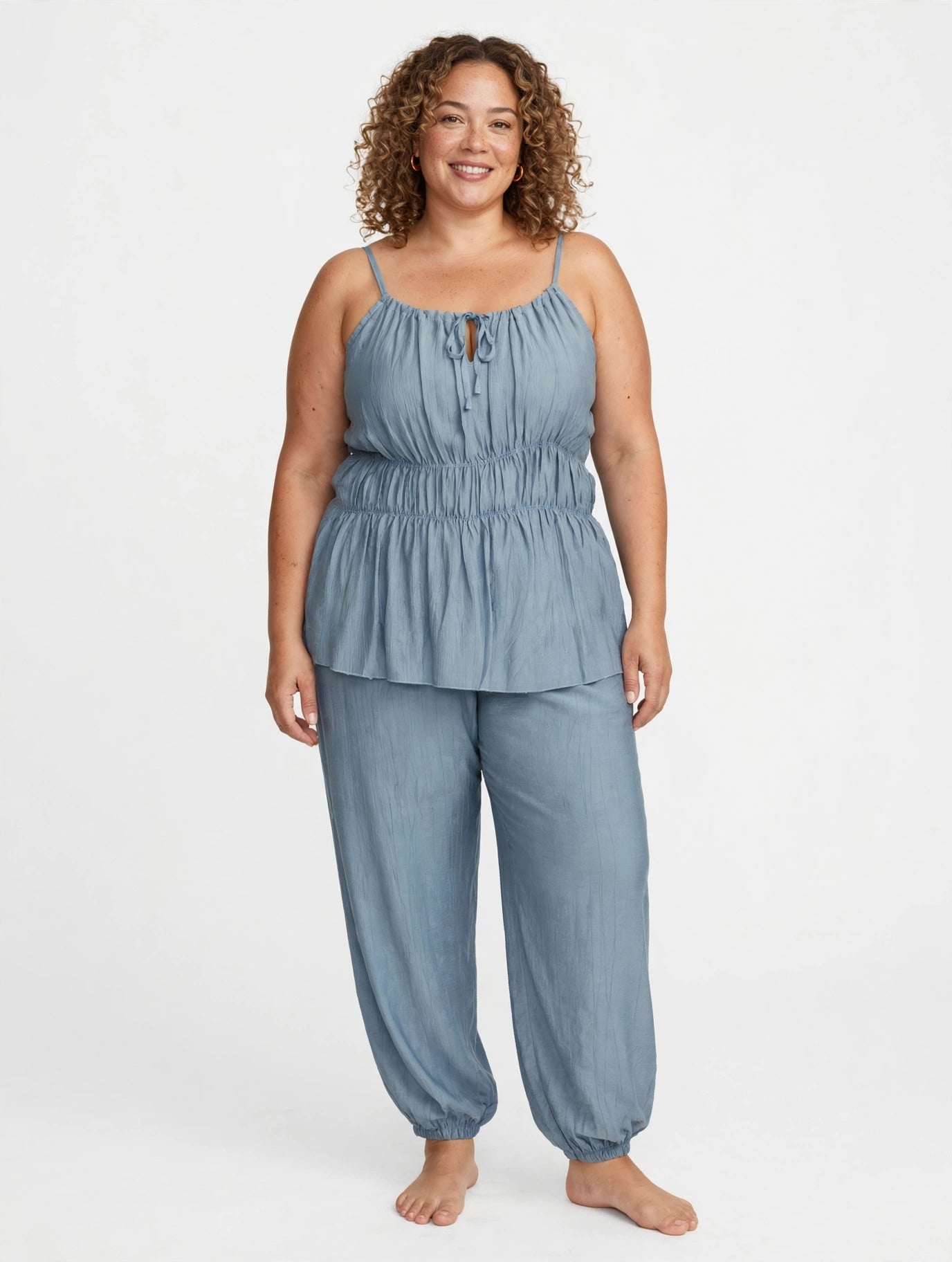 Modelo sonriente vistiendo conjunto azul de las cucadas de erisa con top de tirantes fruncido y pantalón cómodo