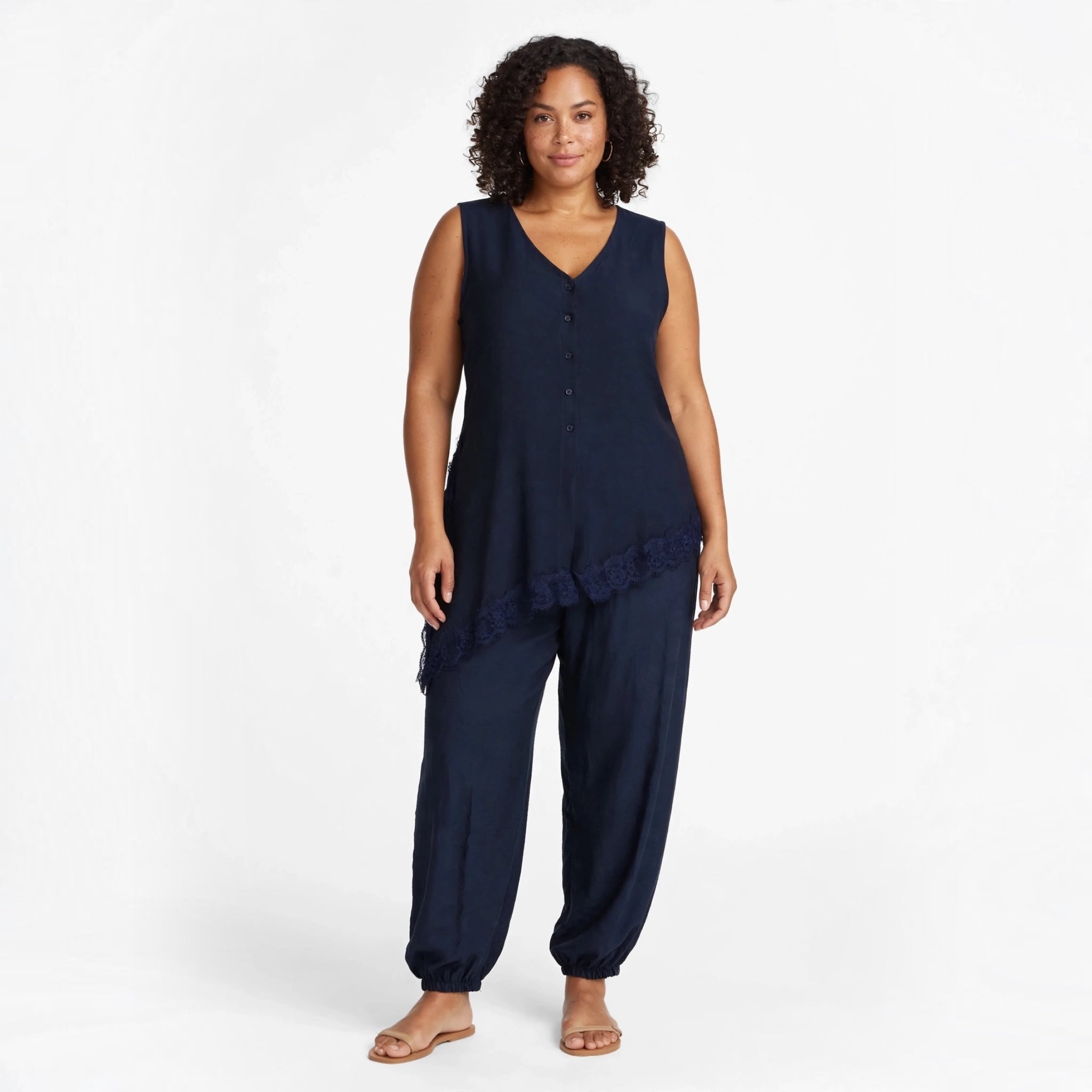 Modelo con conjunto azul marino de las cucadas de erisa, blusa sin mangas asimétrica con encaje y pantalón estilo jogger