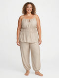 Modelo sonriente vistiendo conjunto de dos piezas beige de las cucadas de erisa con top fruncido y pantalón holgado