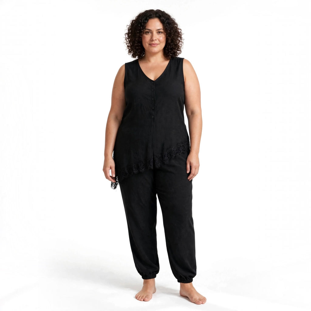 Modelo con conjunto negro de las cucadas de erisa, blusa sin mangas asimétrica con encaje y pantalón estilo jogger
