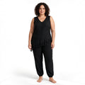 Modelo con conjunto negro de las cucadas de erisa, blusa sin mangas asimétrica con encaje y pantalón estilo jogger