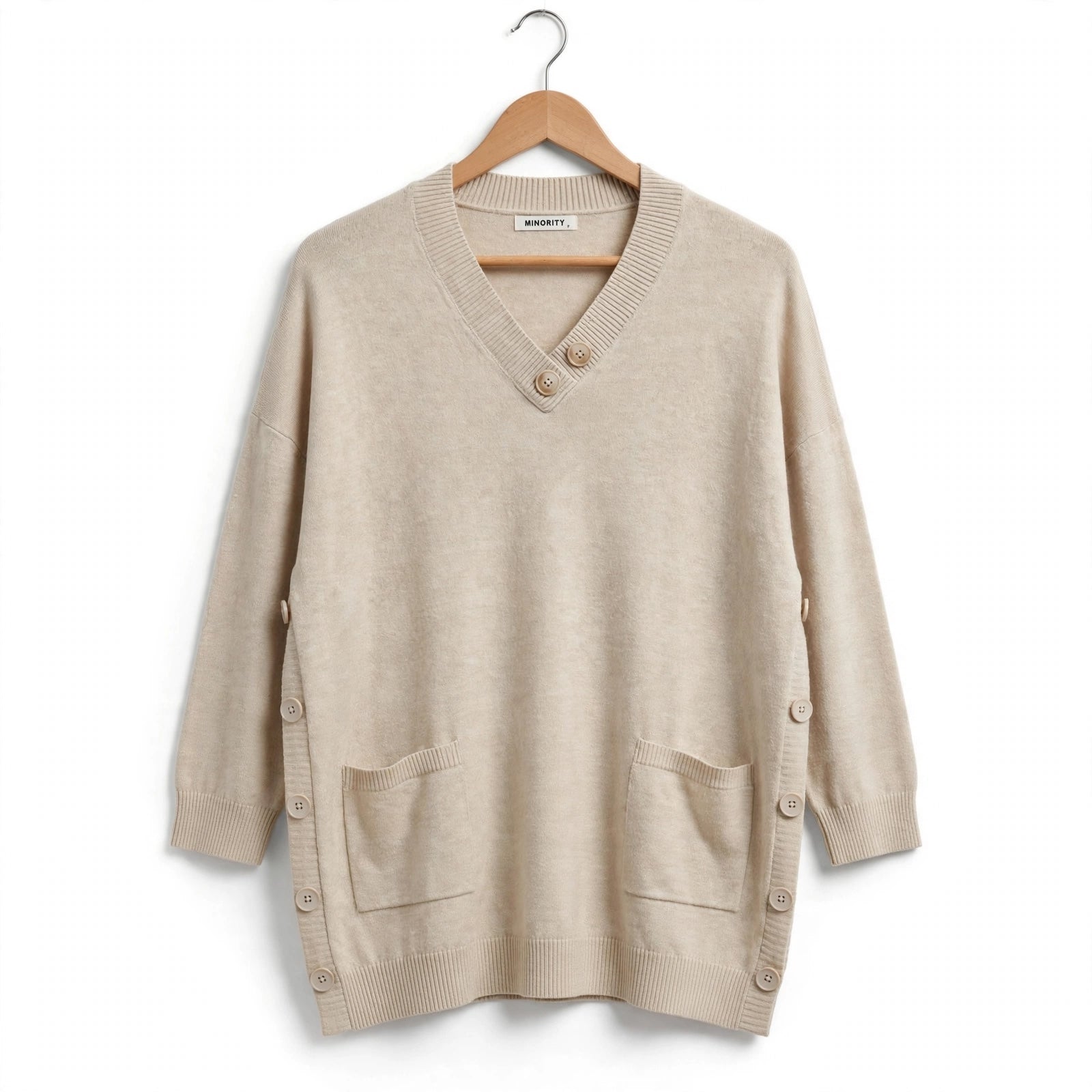 Jersey de punto las cucadas de erisa beige con cuello en V, botones decorativos, bolsillos frontales y laterales.
