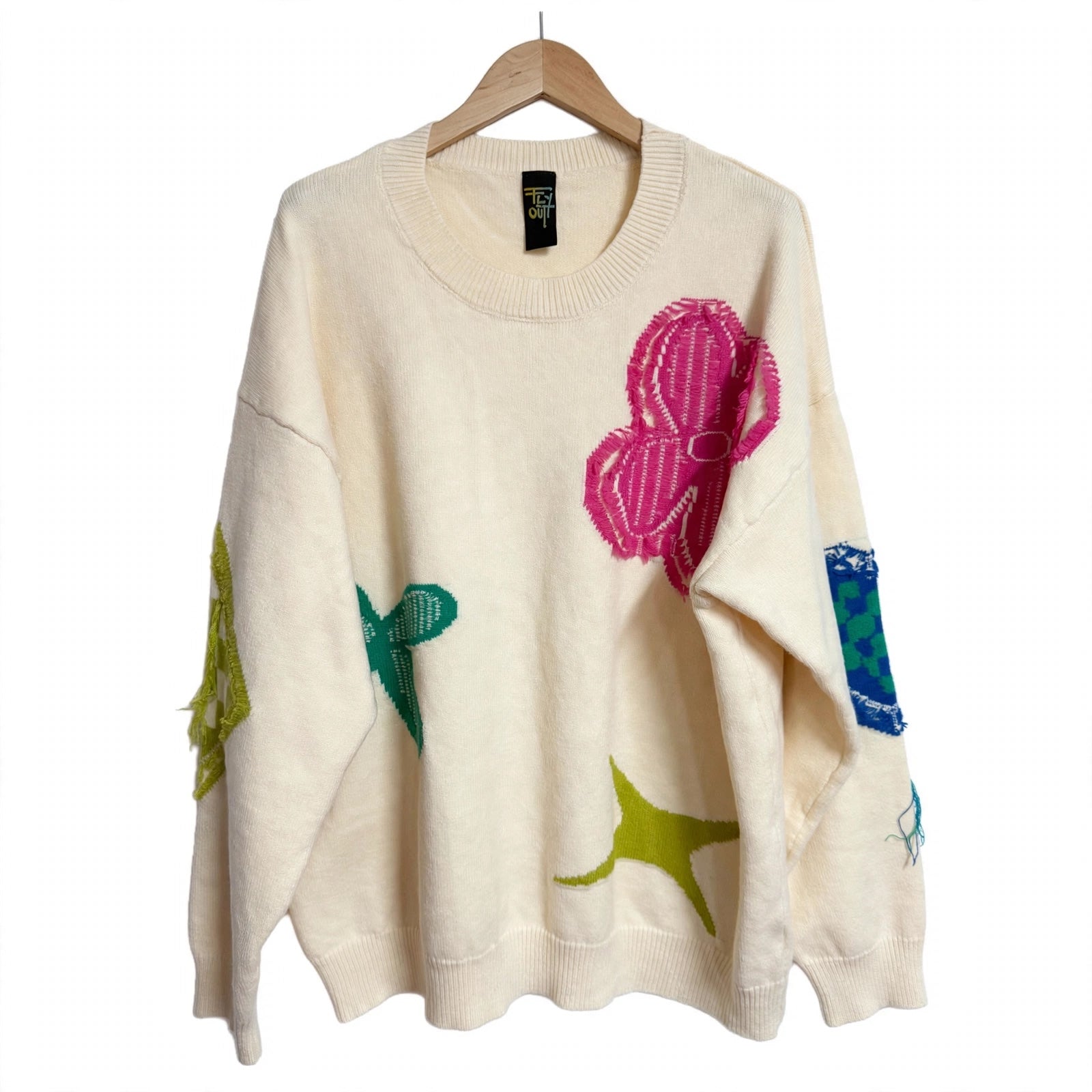 Jersey de punto crema de las cucadas de erisa con bordados vibrantes fucsia, verde y azul y detalles deshilachados.