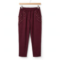 Pantalones las cucadas de erisa color burdeos con tacto ante, cintura elástica y bolsillos con lentejuelas y bordados.