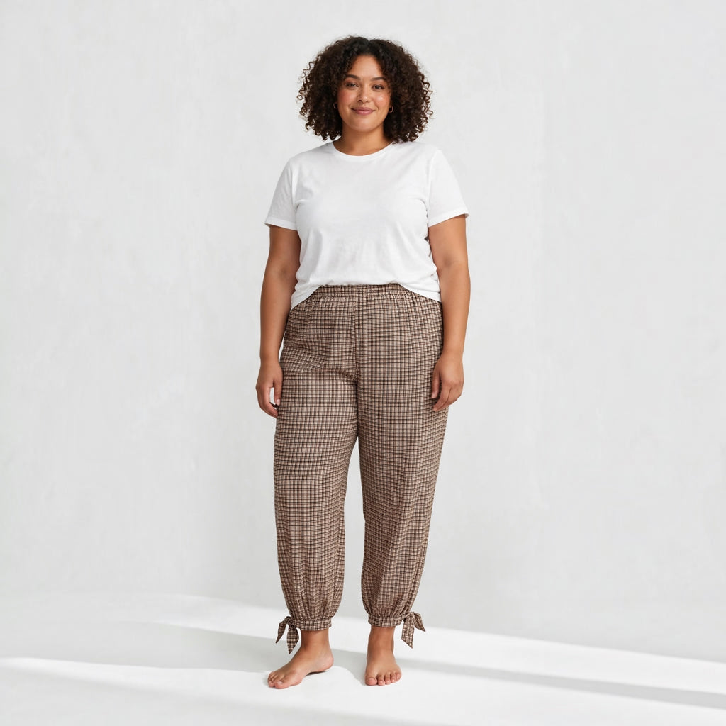 Modelo con pantalones de cuadros marrones de las cucadas de erisa, corte relajado, cintura elástica y bajos con lazos