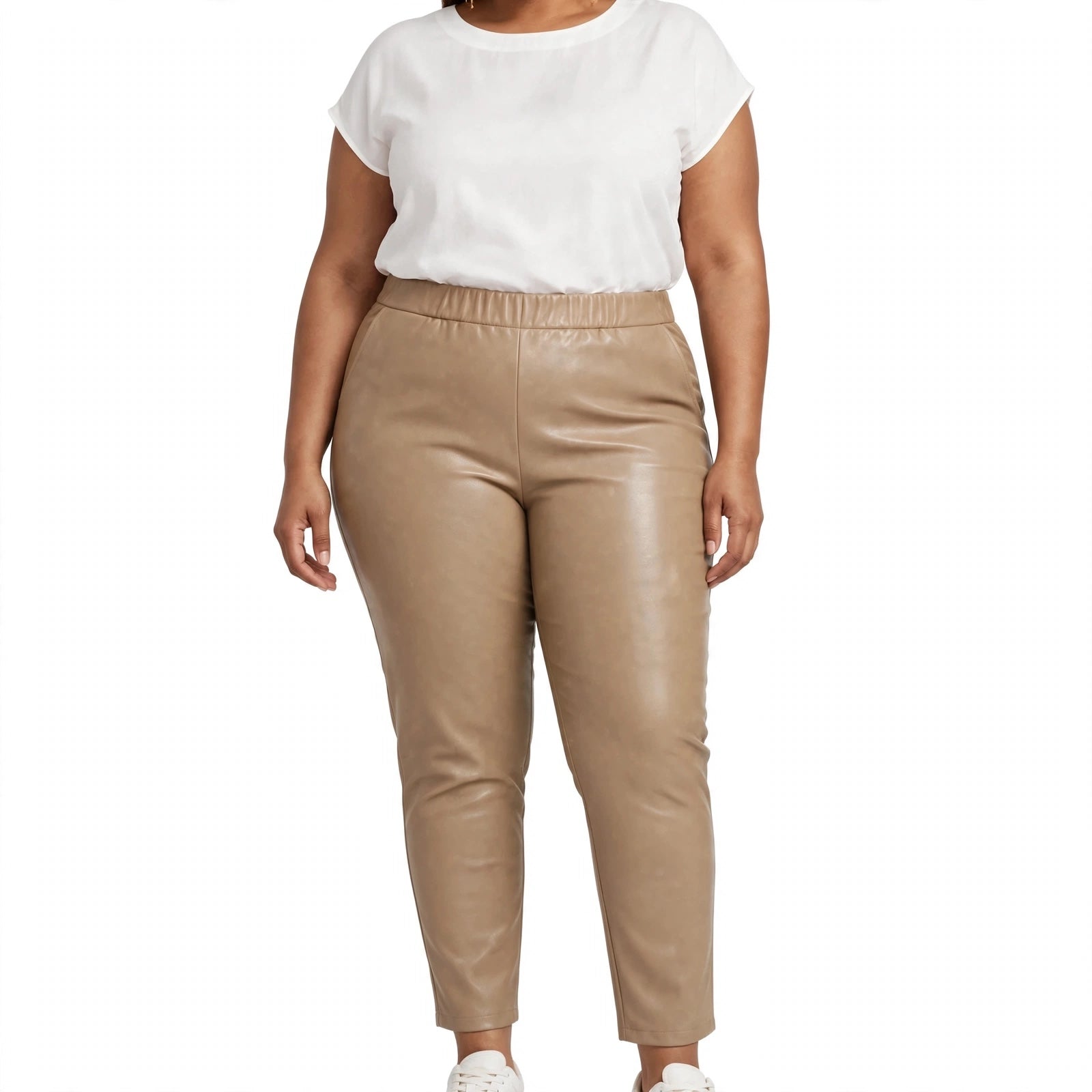 Modelo vistiendo pantalones las cucadas de erisa de efecto piel en color beige con cintura elástica y bolsillos