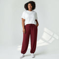 Modelo con pantalones jogger burdeos de las cucadas de erisa, corte holgado, cintura ajustable y puños elásticos.