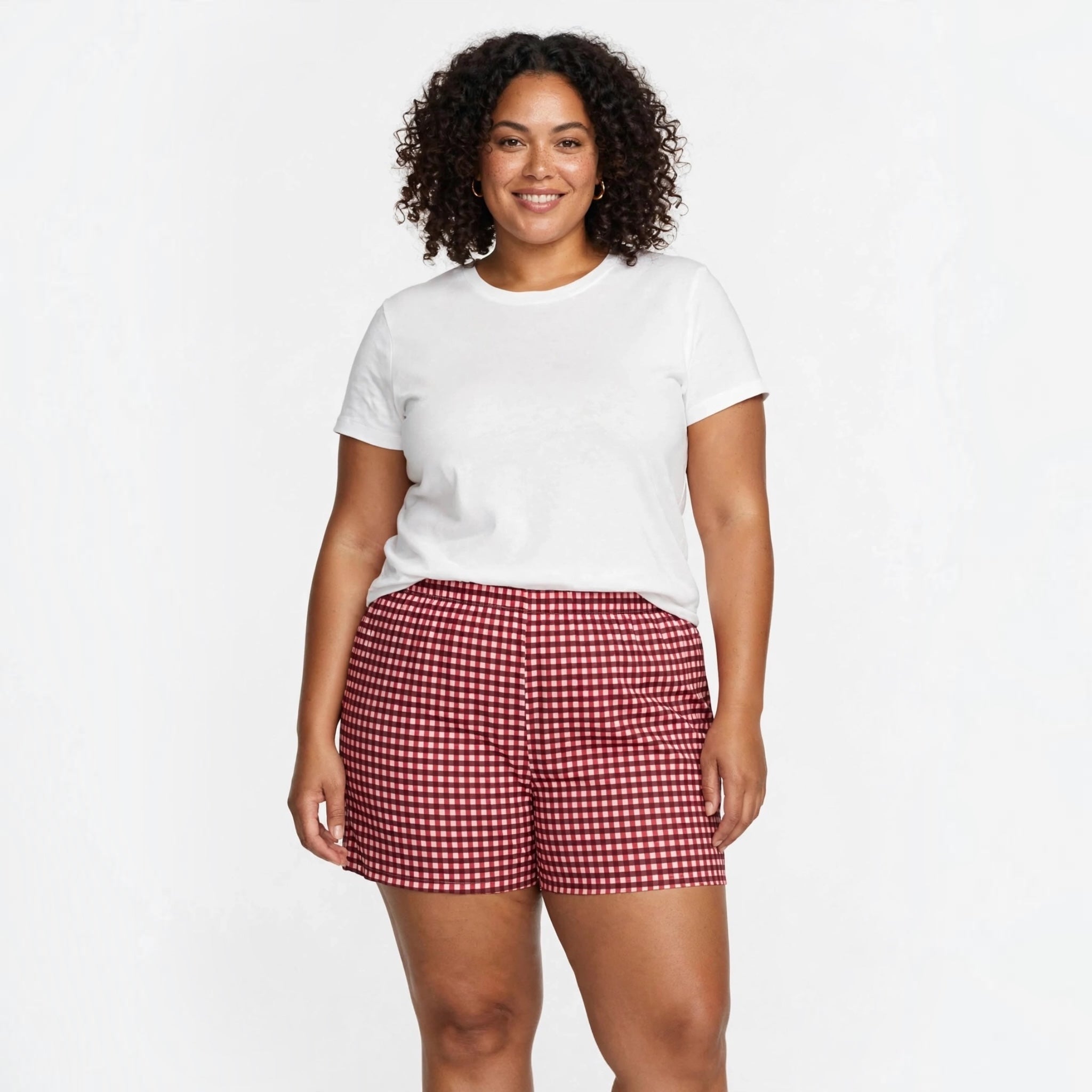 Modelo sonriendo con pantalones cortos de cuadros vichy rojos de las cucadas de erisa y camiseta blanca básica