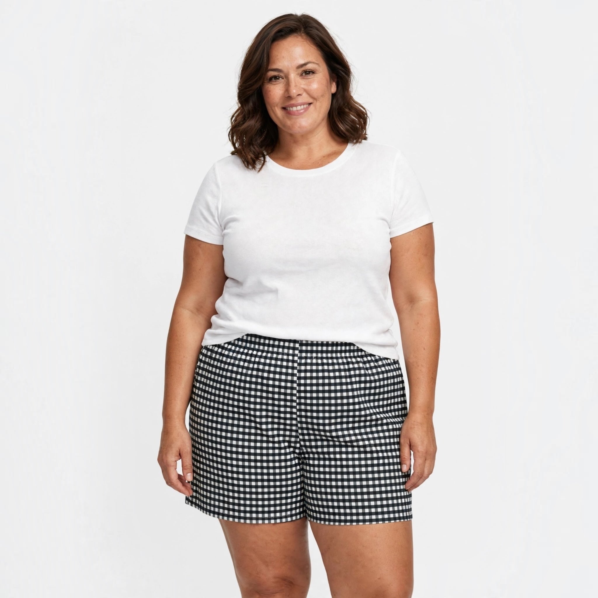 Mujer sonriente vistiendo pantalones cortos de cuadros vichy negros y blancos de las cucadas de erisa con camiseta blanca