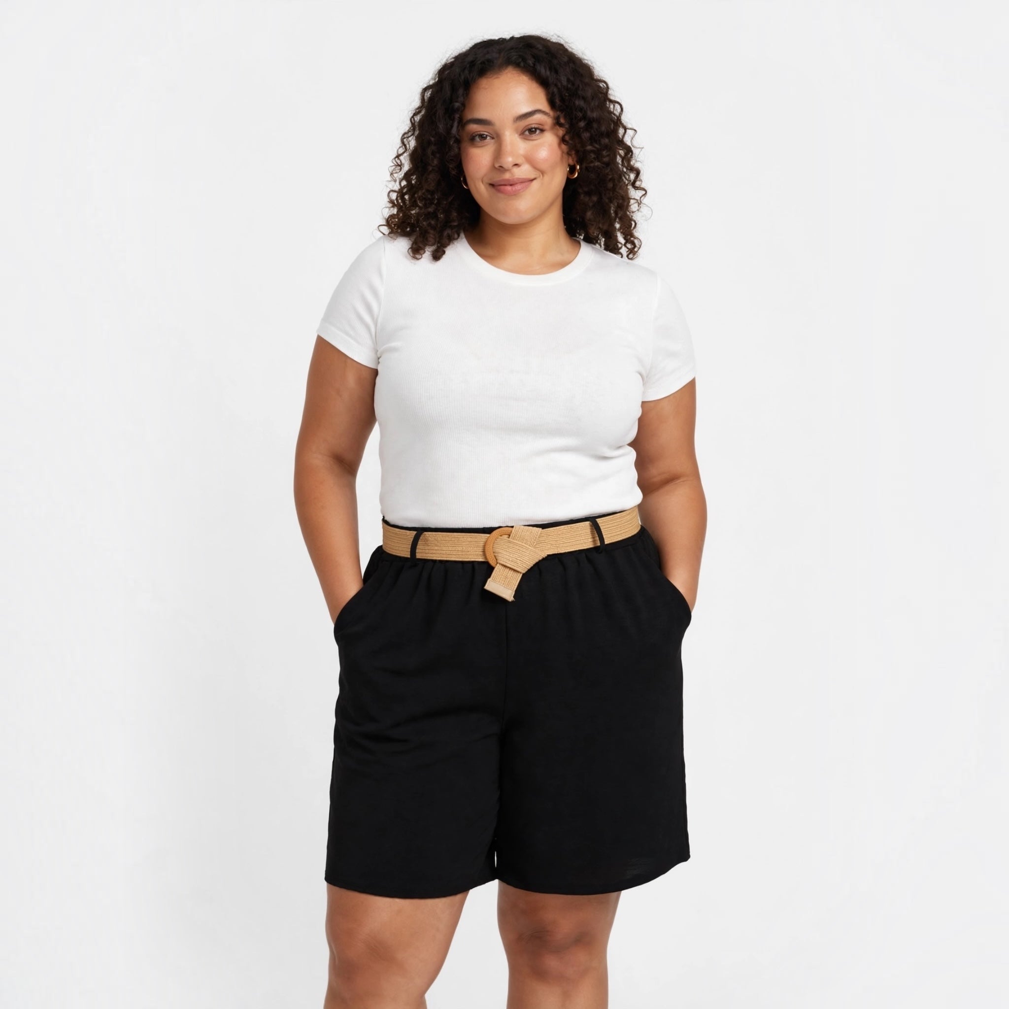 Modelo con shorts negros fluidos de las cucadas de erisa, tiro medio, bolsillos y cinturón de rafia natural.