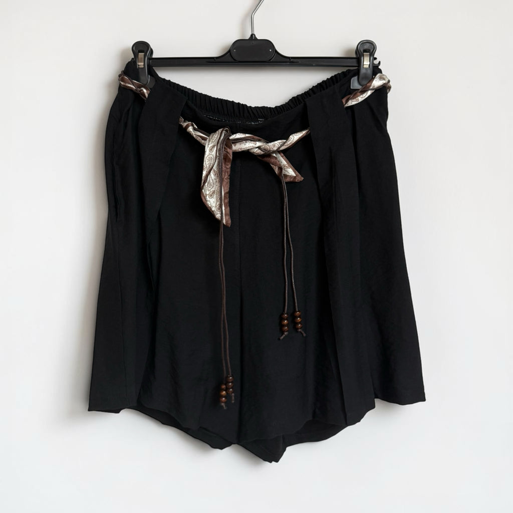 Shorts negros fluidos las cucadas de erisa con cintura elástica y cinturón tipo pañuelo estampado con abalorios.