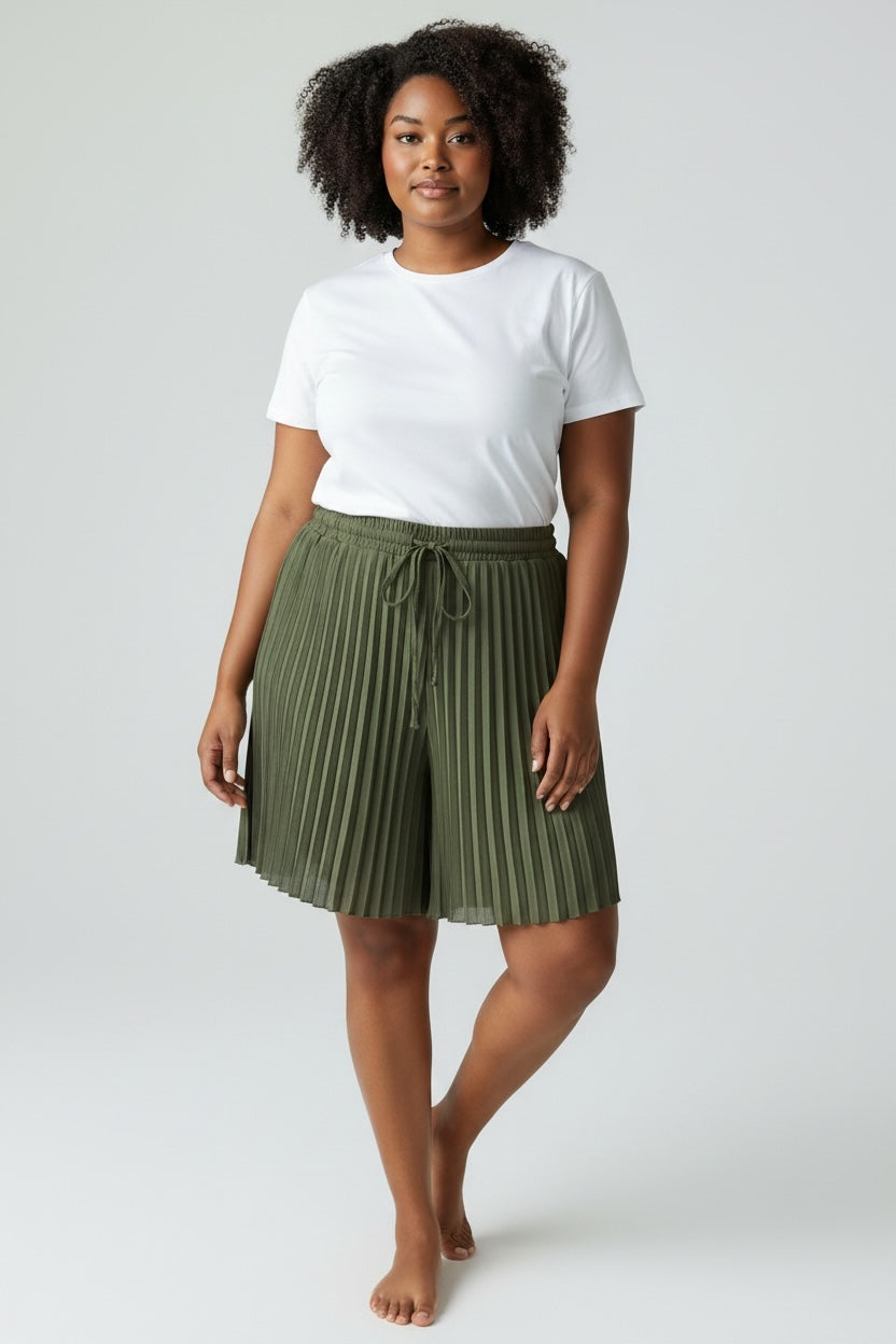 Modelo con shorts plisados verde oliva de las cucadas de erisa, cintura elástica con cordón y tejido fluido ligero.