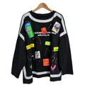 Sudadera oversize negra las cucadas de erisa con parches coloridos, salpicaduras de pintura y detalles gráficos.