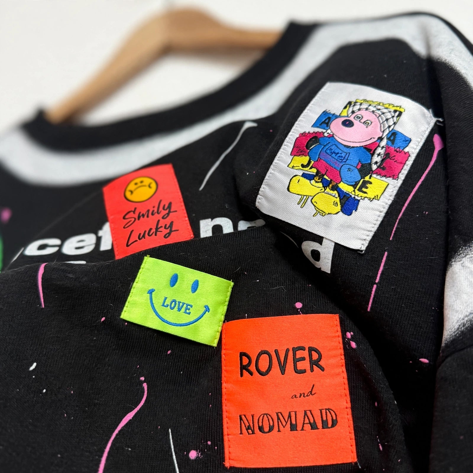 Sudadera oversize negra de las cucadas de erisa con parches coloridos, gráficos y efecto de salpicaduras de pintura.