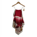 Top tipo pañuelo las cucadas de erisa en rojo con estampado de paisaje costero, tirantes finos y borlas decorativas.
